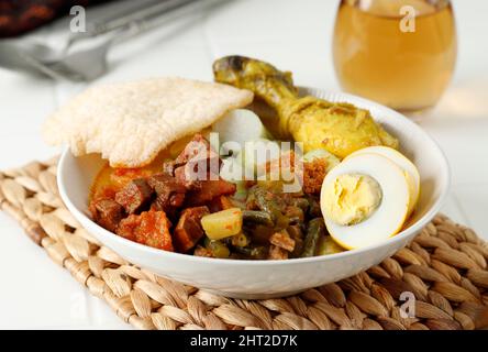 Lontong Sayur Labu Siam ou Sayur Ketuplat, cuisine culinaire indonésienne traditionnelle à base de Chayote, cuite avec du lait de coco et des épices, servi avec du riz Banque D'Images