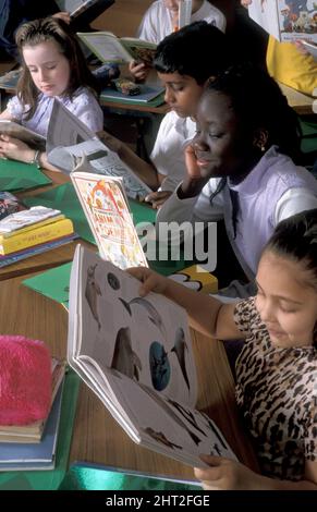 groupe d'enfants multiculturels lisant en classe Banque D'Images