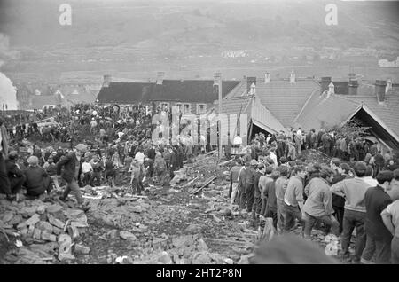 Aberfan - 21st octobre 1966 les hommes locaux et les services d'urgence creusent à la hâte dans la boue pour les survivants de la Pantans Junior School. Ils forment des lignes pour déplacer des seaux de boue, d'un à l'autre, loin de la scène. Et pour être en ligne, en se déplaçant vers le haut de la file d'attente pour leur tour à creuser. Le désastre d'Aberfan a été l'effondrement catastrophique d'un pourboire de collierie dans le village gallois d'Aberfan, près de Merthyr Tydfil. Elle a été causée par une accumulation d'eau dans la roche accumulée et le schiste, qui a soudainement commencé à glisser en descente sous forme de lisier et a englouti la Pantans Junior School ci-dessous Banque D'Images