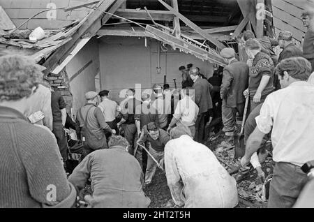 Aberfan - 21st octobre 1966 les hommes locaux et les services d'urgence creusent à la hâte dans la boue pour les survivants de la Pantans Junior School. Le désastre d'Aberfan a été l'effondrement catastrophique d'un pourboire de collierie dans le village gallois d'Aberfan, près de Merthyr Tydfil. Elle a été causée par une accumulation d'eau dans la roche accumulée et le schiste, qui a soudainement commencé à glisser en descente sous forme de lisier et a englouti la Pantglas Junior School ci-dessous, le 21st octobre 1966, tuant 116 enfants et 28 adultes. Le site de l'école d'origine est maintenant un jardin commémoratif. Photo prise le 21st octobre 1966The même Banque D'Images