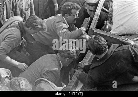 Aberfan - 21st octobre 1966 à l'école Pantglas Junior, les villageois locaux et les services d'urgence s'aident mutuellement à déplacer du bois et des obstacles, espérant atteindre ceux qui sont coincés dans la boue. Le désastre d'Aberfan a été l'effondrement catastrophique d'un pourboire de collierie dans le village gallois d'Aberfan, près de Merthyr Tydfil. Elle a été causée par une accumulation d'eau dans la roche accumulée et le schiste, qui a soudainement commencé à glisser en descente sous forme de lisier et a englouti la Pantglas Junior School ci-dessous, le 21st octobre 1966, tuant 116 enfants et 28 adultes. L'école d'origine est assise Banque D'Images