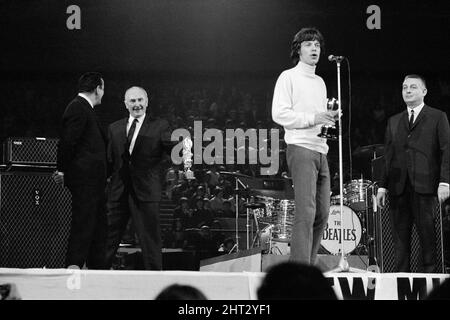 New musical Express Poll Winners concert pop à Empire Pool Wembley, 1965. The Rolling Stones a remporté le prix du meilleur groupe R & B britannique ainsi que le meilleur nouveau disque de l'année pour sa seule satisfaction (In't get No). Sur la photo, le chanteur Mick Jagger accepte les prix. 11th avril 1965. Banque D'Images