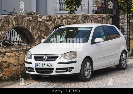 Side, Turquie – 06 2022 février : le Polo blanc Volkswagen est stationné dans la rue par une chaude journée sur fond de clôture Banque D'Images