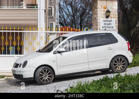 Side, Turquie – 06 2022 février : le Polo blanc Volkswagen est stationné dans la rue par une chaude journée sur fond de clôture Banque D'Images