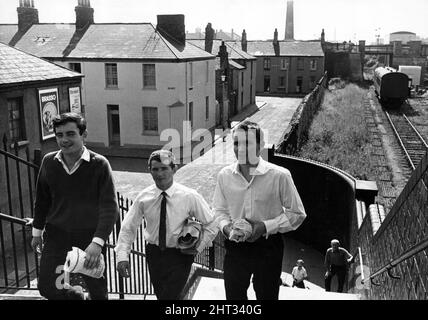 Newtown était une zone résidentielle de Cardiff, au pays de Galles, qui existait du milieu du XIXe siècle jusqu'à sa démolition en 1970. Sur la photo, trois jeunes hommes franchissant la passerelle au-dessus de la ligne de chemin de fer. Vers 1965. Banque D'Images