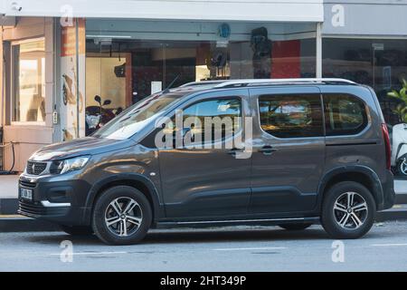 Side; Turquie – février 06 2022 : Gray PEUGEOT RIFTER se stationne dans la rue sur un fond de soleil avec un bâtiment, une boutique Banque D'Images