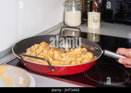 Faire une casserole avec la viande et le sauté pour faire une paella dans la cuisine d'une maison. Banque D'Images