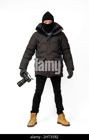 Photographe vêtu de parka noire et de vêtements d'hiver. Banque D'Images