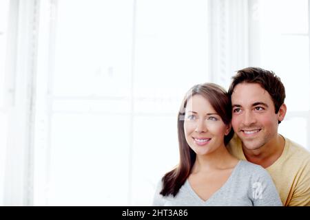 Rêver de faire une famille - Copysapce. Jeune couple attrayant debout à l'intérieur ensemble et regardant loin - CopySpace. Banque D'Images