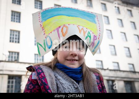 Londres, Royaume-Uni, 26th février 2022 Alice porte son panneau de protestation sur la tête - c'est plus facile que du porter toute la journée. Elle est venue avec sa famille pour rejoindre les milliers de personnes qui se sont rassemblées à Whitehall pour protester contre la récente attaque russe contre l'Ukraine. Banque D'Images