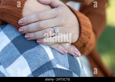 Gros plan des mains de la mariée reposant sur la chemise à carreaux de l'homme. Banque D'Images