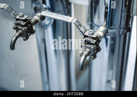 Canalisations minces avec leviers bleus ouverts et fermés à l'usine Banque D'Images
