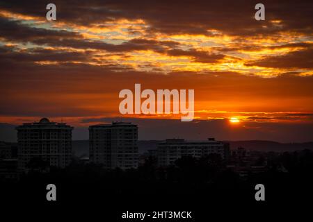 Un lever de soleil doré au-dessus d'un paysage urbain et d'un beau ciel nuageux Banque D'Images
