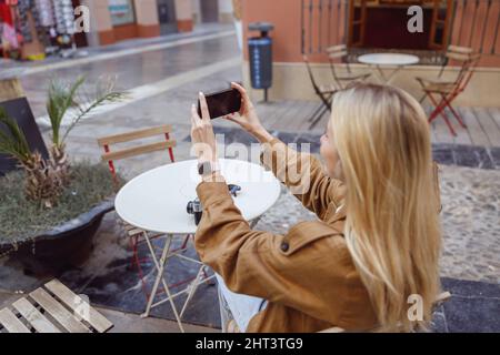 Gros plan d'une femme tenant un téléphone et prenant une photo du bâtiment Banque D'Images