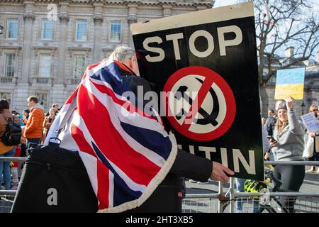 Londres, Royaume-Uni, 26th février 2022 Un homme drapé dans un drapeau de l'Union tient un panneau alors que des milliers de personnes se sont rassemblées à Whitehall pour protester contre la récente attaque de la Russie contre l'Ukraine. Banque D'Images