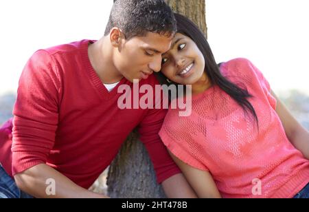 Elle partage ses rêves. Photo d'un jeune couple heureux partageant un moment affectueux en plein air. Banque D'Images