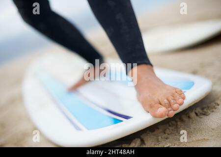 Avoir une idée de la carte. Photo courte d'un pied de surfeurs femelles méconnaissable sur une planche de surf. Banque D'Images