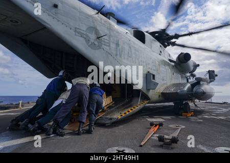 OCÉAN PACIFIQUE (fév 24, 2022) des marins et des Marines chargent du fret sur un Super Stallion CH-53E attaché à l'escadron marin à rotor inclinable (VMM) 165 (renforcé), 11th Marine Expeditionary Unit (MEU), sur le pont de vol du quai amphibie de la classe Harpers Ferry USS Pearl Harbor (LSD 52), dans l'océan Pacifique, 24 février 2022. Les marins et les marins du Essex Amphiobie Ready Group (ARG) et du MEU 11th sont en train de mener des opérations de routine dans la flotte américaine 3rd. (É.-U. Photo de la marine par le spécialiste des communications de masse 3rd classe sang Kim) Banque D'Images