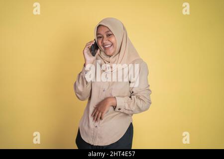 Femme asiatique en hijab utilisant un téléphone cellulaire Banque D'Images