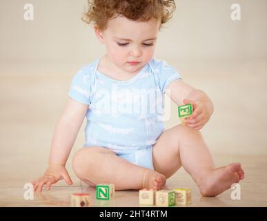 Des éléments de base pour un avenir radieux. Prise de vue en longueur d'un bébé mignon jouant avec des blocs de jouets. Banque D'Images