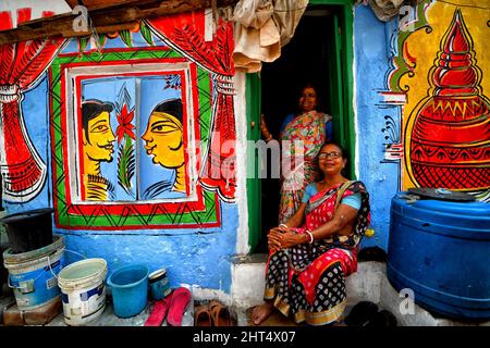 Kolkata, Inde. 26th févr. 2022. Les femmes vues dans un cadre coloré de taudis avec de beaux graffitis de mur.Kolkata rues et différents bidonvilles vu se peindre avec des graffitis colorés comme une initiative d'un art Fest (Behala Art Fest) en cours à Kolkata. Des artistes de différents collèges d'art ont participé pour rendre la ville plus belle. Crédit : SOPA Images Limited/Alamy Live News Banque D'Images