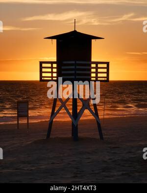 Un beau portrait de la silhouette d'une maison de maître-nageur face au coucher du soleil sur la plage Banque D'Images