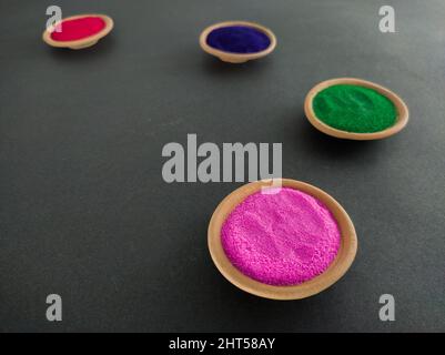 poudres colorées pour holi sur pots d'argile à l'occasion du festival indien des couleurs. happy holi thème tourné sur fond noir. espace de copie pour le texte. Banque D'Images