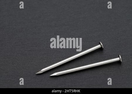 clous métalliques argentés sur fond noir Banque D'Images
