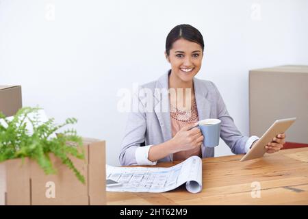 Vérification des e-mails professionnels. Prise de vue d'une jeune designer qui travaille avec joie sur sa tablette. Banque D'Images