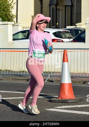 Brighton, Royaume-Uni. 27th fév. 2022. Cette coureuse est accroché à son chapeau lorsqu'elle participe au semi-marathon de Brighton lors d'une matinée ensoleillée mais froide sur la côte sud : Credit Simon Dack/Alay Live News Banque D'Images