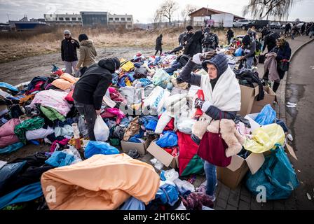 Przemysl, Pologne. 27th févr. 2022. Après avoir traversé la frontière entre Shehyni en Ukraine et Medyka en Pologne, les réfugiés cherchent des vêtements et des couvertures fournis par des volontaires polonais auprès des policiers. De nombreux Ukrainiens quittent le pays après des actions militaires de la Russie sur le territoire ukrainien. Credit: Michael Kappeller/dpa/Alay Live News Banque D'Images