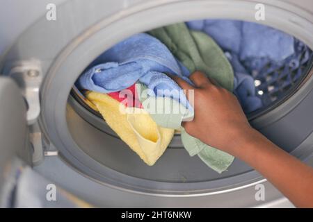 mettre une serviette et des chiffons dans un lave-linge. Banque D'Images