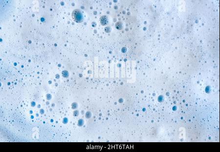 Savon nettoyant mousse bulles texture sur fond bleu Banque D'Images