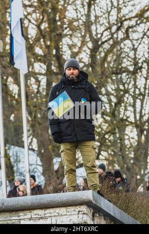 Manifestation sur la place de la liberté, dans l'État de l'OTAN en Estonie, en faveur de l'Ukraine et contre l'agression russe. Homme portant un drapeau ukrainien Banque D'Images