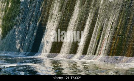 Barrage fluvial avec eau claire et fluide par une chaude journée Banque D'Images