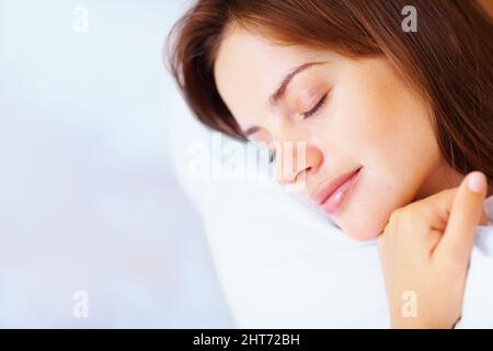 Gros plan d'une jolie femme qui dormait rapidement au lit. Portrait en gros plan d'une jeune femme mignonne qui s'endormit rapidement au lit. Banque D'Images