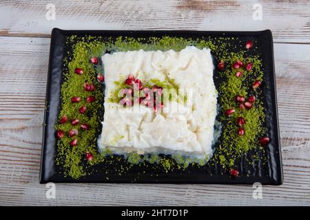 Ramadan traditionnel turc dessert le Gullac sur la table. Il est fait avec du gullac, du lait, de l'eau de rose, du noyer, de la vanille. Il est décoré de grenade Banque D'Images