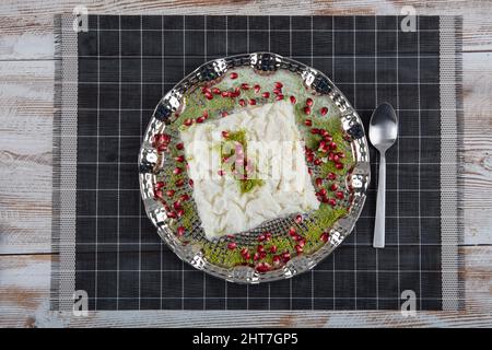 Ramadan traditionnel turc dessert le Gullac sur la table. Il est fait avec du gullac, du lait, de l'eau de rose, du noyer, de la vanille. Il est décoré de grenade Banque D'Images