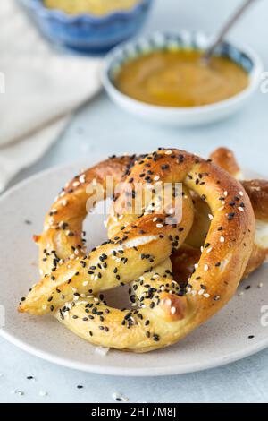 Gros plan sur un bretzel cuit maison, garni de tout ce qui est assaisonné. Banque D'Images