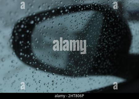 Gros plan d'une fenêtre de voiture humide avec du verre recouvert de gouttes de pluie Banque D'Images