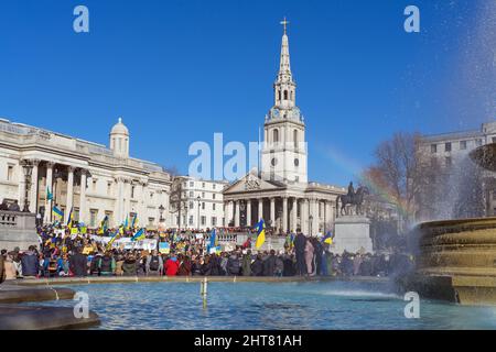 Protestation contre l'invasion russe de l'Ukraine sur la place Trafalgar. Un grand groupe de manifestants tenant des bannières et des drapeaux ukrainiens. Londres Banque D'Images