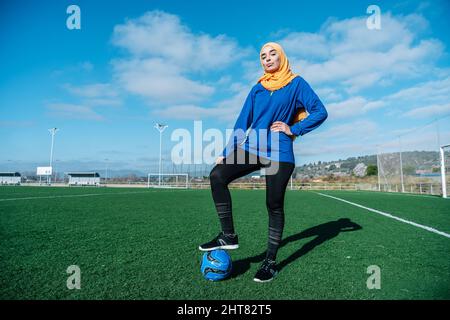Joueuse de football arabe féminine avec ballon sur le terrain Banque D'Images
