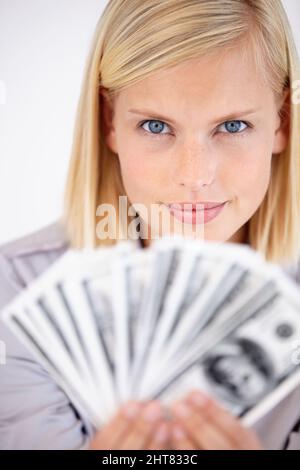 Vous devez travailler dur si vous le souhaitez. Une femme tenant une main d'argent avec un regard stimulant dans ses yeux. Banque D'Images