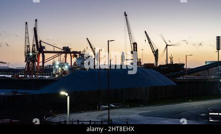 Le soleil se couche sur les quais d'Avonmouth tandis que les gros navires de cargaison en vrac sont déchargés à Bristol. Banque D'Images