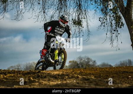 Pilote professionnel avec un casque dans une course de motocross sur une piste de sable à Marysville, CA Banque D'Images