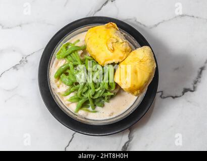 nourriture malaisienne élicieuse cendol durian dans un bol noir avec du lait sucré glacé, du lait de coco, du riz vert et du sucre de palme isolé sur fond de marbre gris Banque D'Images