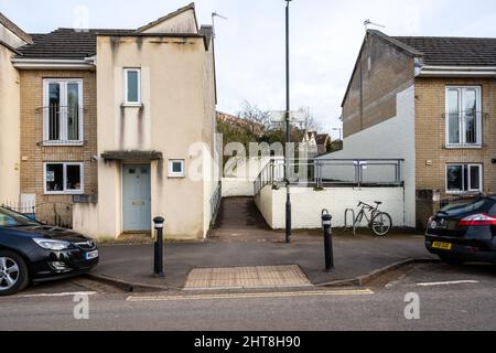 Une construction de chaussée crée un point de passage piétonnier informel entre les places de stationnement dans une rue résidentielle. Banque D'Images