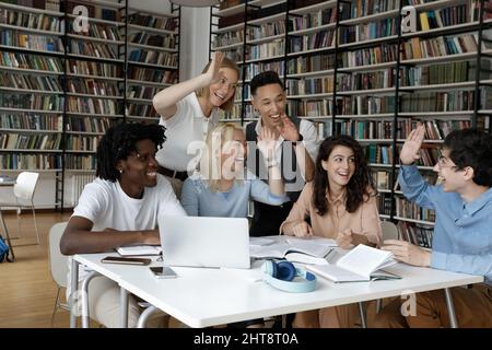 Jeunes étudiants multiethniques joyeux qui se donnent cinq élèves les uns aux autres. Banque D'Images