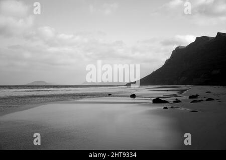 Plage sauvage avec falaises en arrière-plan, Caleta de Famara, Lanzarote, îles Canaries, Espagne Banque D'Images