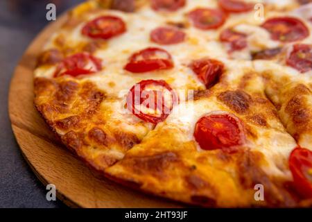 pizza margherita sur une assiette en bois de gros plan. Banque D'Images
